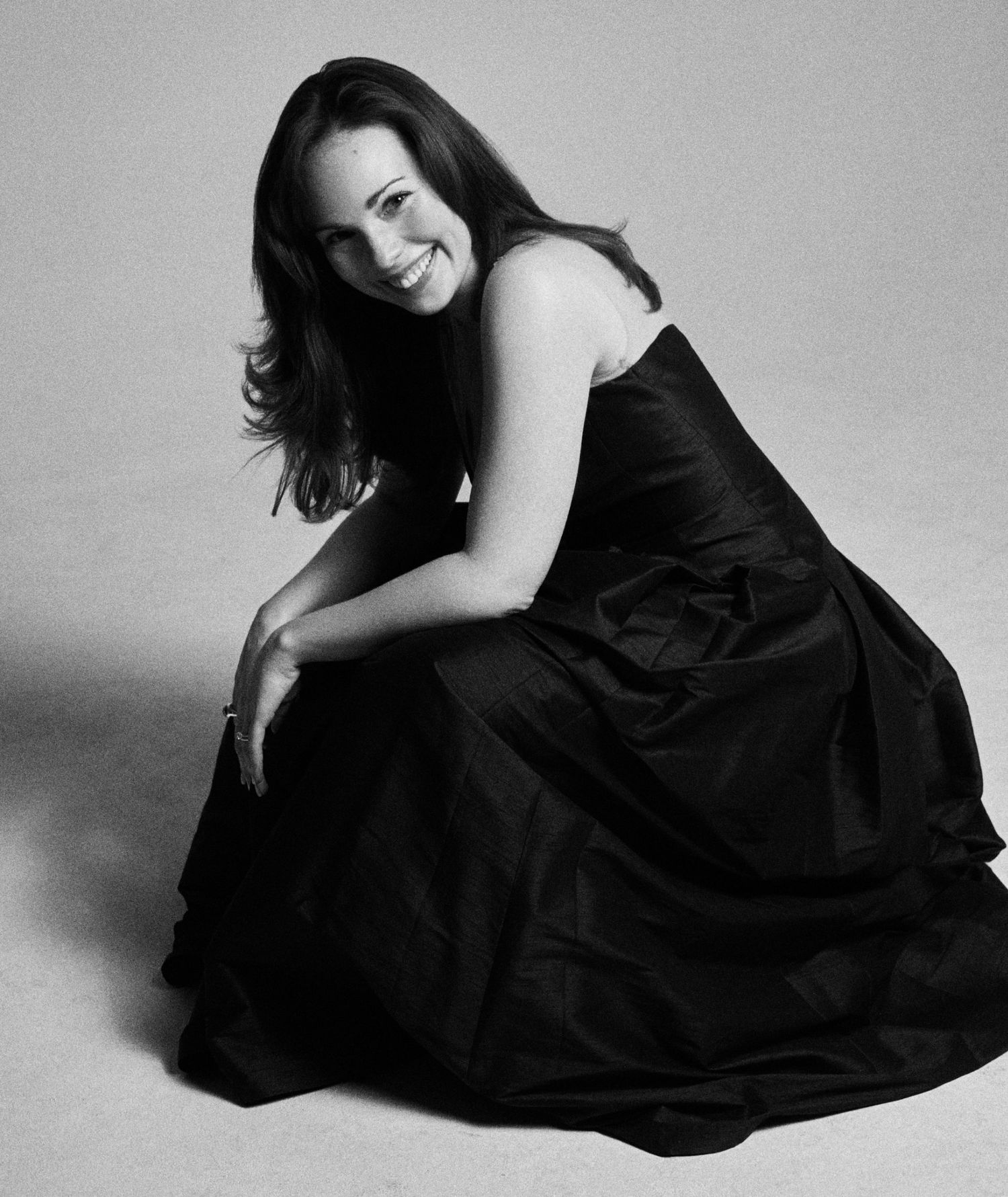 Alexandra Yangel seated in a black dress, smiling