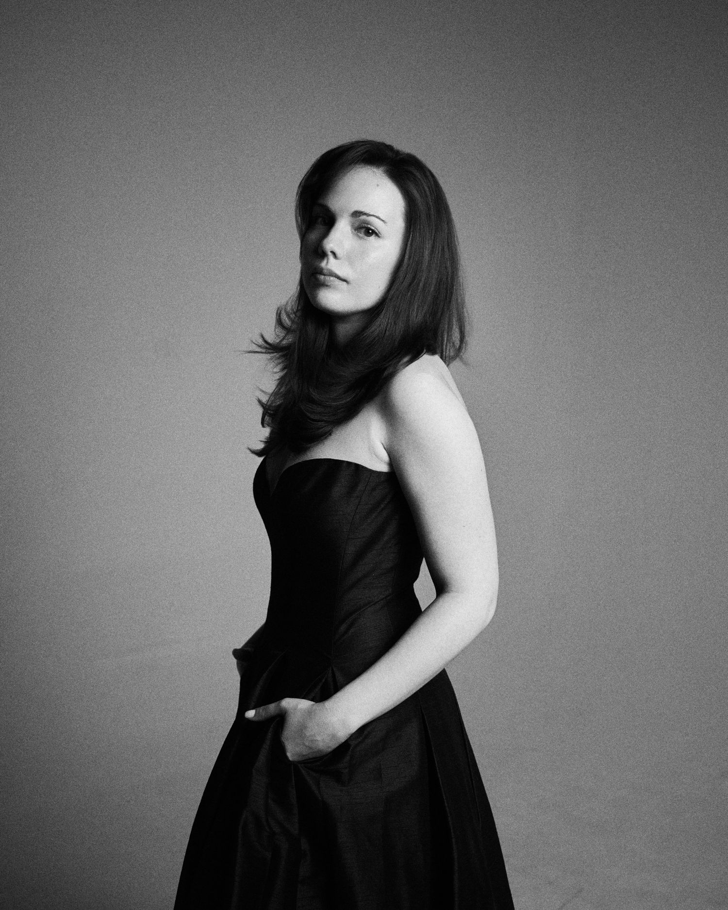 Alexandra Yangel standing in a black gown, one hand in her pocket