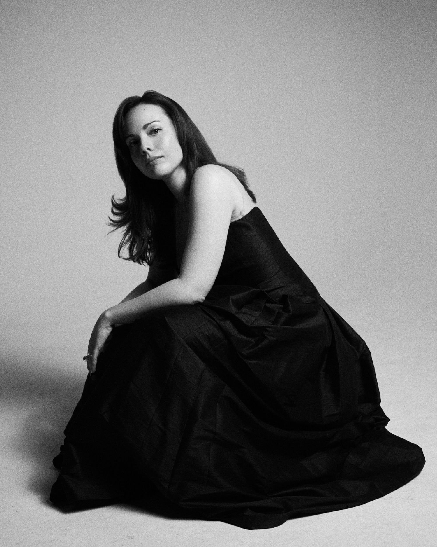 Alexandra Yangel seated on the floor, the skirt of her gown spread around her