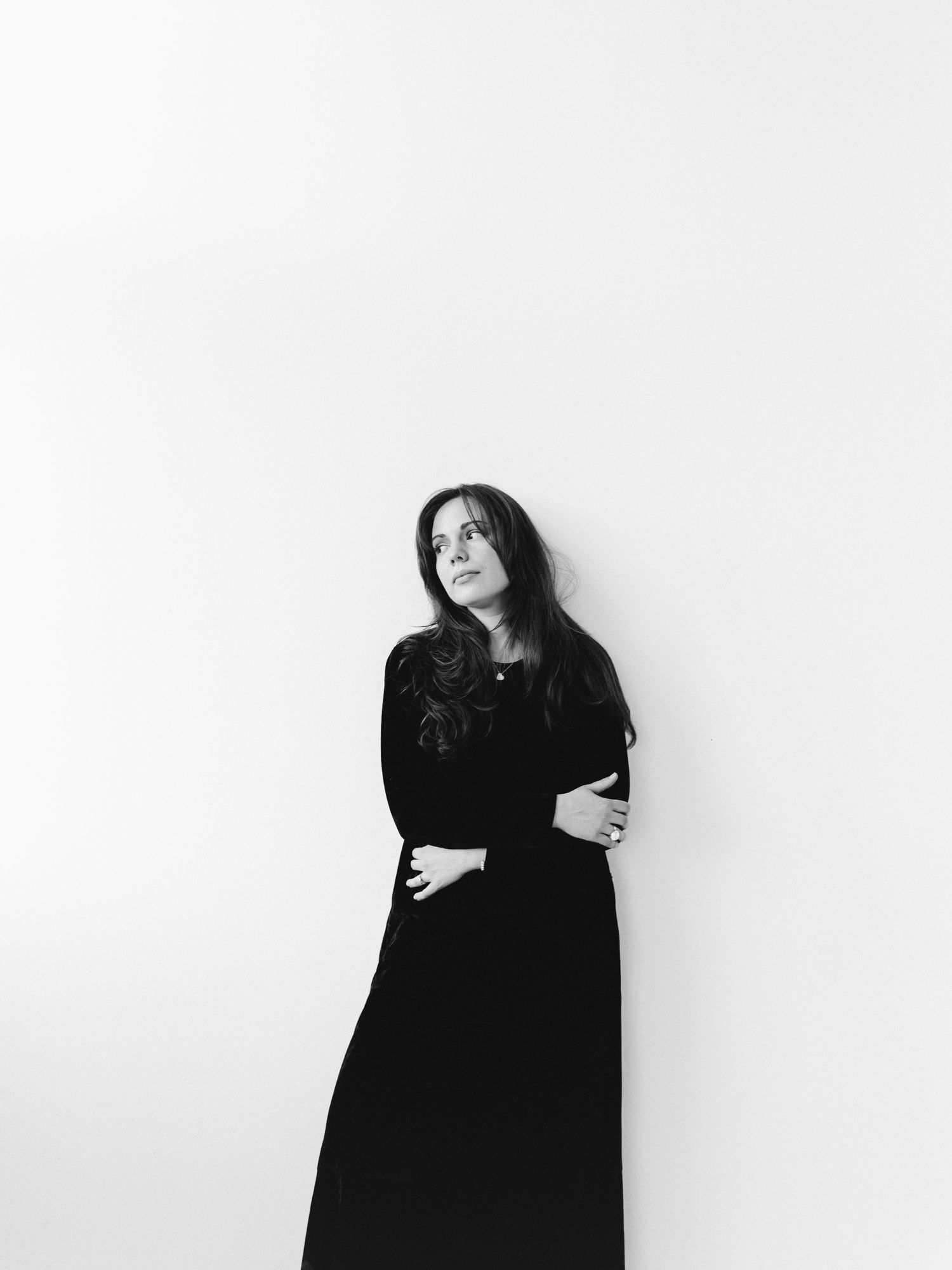 Alexandra Yangel standing with her arms crossed in a long black dress