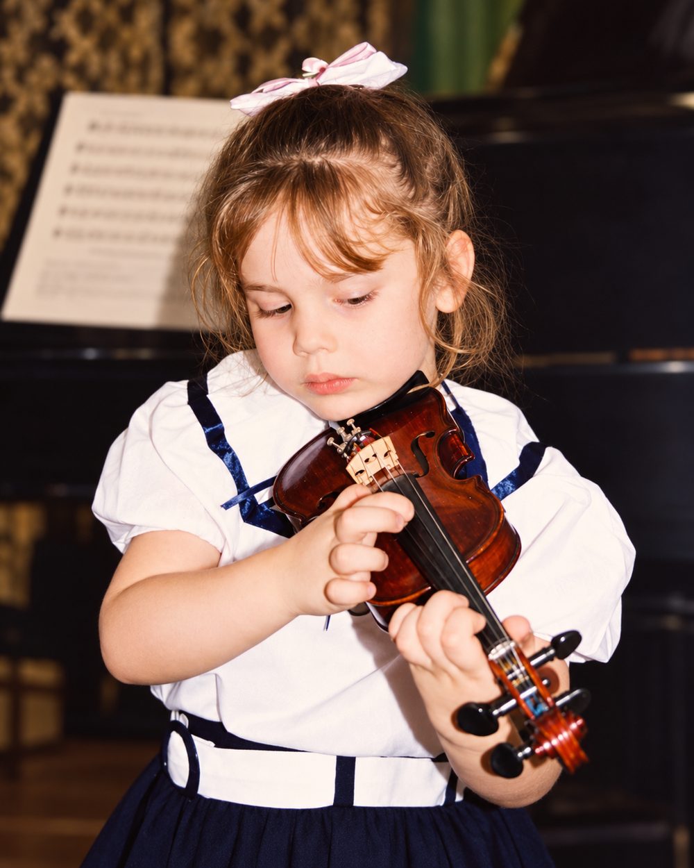 Alexandra Yangel as a young child, a violin held under her chin